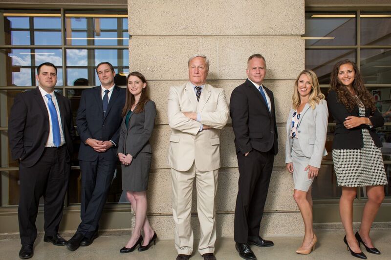 seven attorneys standing in front of a building with windows