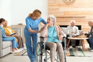 older women in a wheel chair being comforted by a nurse